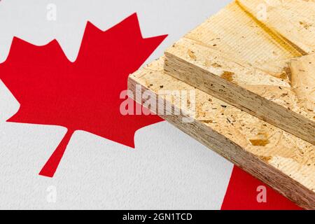 OSB, orientiertes Strangbrett, Sperrholz auf Flagge Kanadas. Handelskrieg, Zölle, fairer Handel und Holz, Holzwirtschaft Konzept. Stockfoto