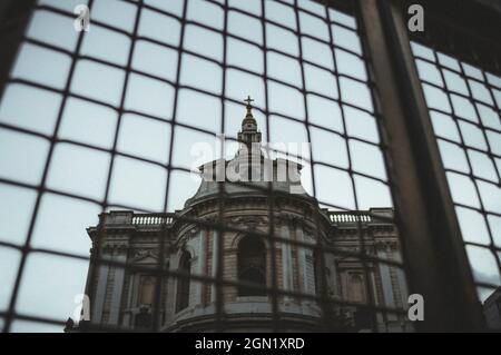 Die alte Kathedrale spiegelt sich an der Spiegelfassade eines modernen Gebäudes wider Stockfoto