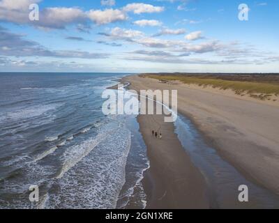 Luftaufnahme von drei Personen, die am Strand in der Nähe der Westerduinen-Dünen entlang der Nordseeküste, bei Den Hoorn, Texel, Westfriesische Isla reiten Stockfoto