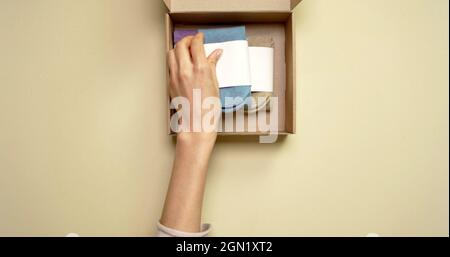 Hand einer Frau, die Socken in eine Kiste nimmt Stockfoto