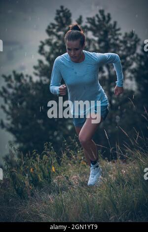 Die junge Frau läuft in der Abendstimmung in Falkenstein, Allgäu, Bayern, Deutschland Stockfoto