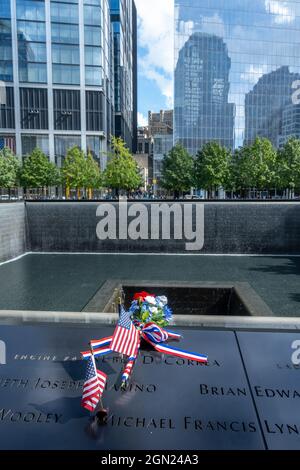 New York, USA, 21. September 2021 - US-Flaggen und Blumen sind neben den Namen der Opfer des Terroranschlags auf der National September 11 Memoria zu sehen
