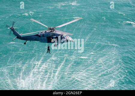 210915-A-UH336-0116 ARABISCHER GOLF (SEPT 15, 2021) – Seeleute, die dem Helicopter Sea Combat Squadron (HSC) 26 zugewiesen wurden, führen im Arabischen Golf am 15. September ein Such- und Rettungssprungtraining mit einem Sea Hawk-Hubschrauber der MH-60S durch. HSC-26 wird im 5. Einsatzgebiet der US-Flotte eingesetzt, um Marineinteraktionen zu unterstützen, um die maritime Stabilität und Sicherheit in der Zentralregion zu gewährleisten, indem es das Mittelmeer und den Pazifik durch den westlichen Indischen Ozean und drei kritische Drosselpunkte mit dem freien Fluss des globalen Handels verbindet. (USA Armee-Foto von SPC. Joseph DeLuco Stockfoto