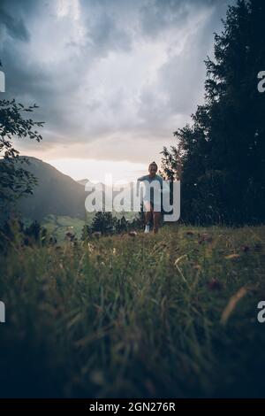 Die junge Frau läuft in der Abendstimmung in Falkenstein, Allgäu, Bayern, Deutschland Stockfoto