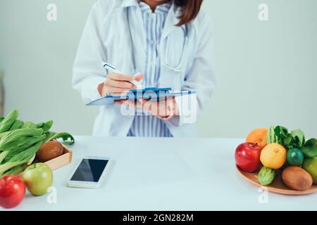 Porträt der Jungen lächelnd weibliche Ernährungsberaterin in der Beratung. Ernährungsberater arbeiten an Diätplan. Stockfoto