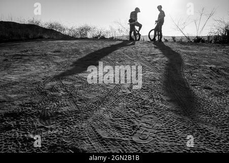 Laguna Beach, Kalifornien, USA. Oktober 2019. Zwei Mountainbiker in Silhouette reden, während in Laguna Coast Wilderness ein langer Schatten auf den Boden geworfen wird. (Bild: © Ruaridh Stewart/ZUMA Press Wire) Stockfoto