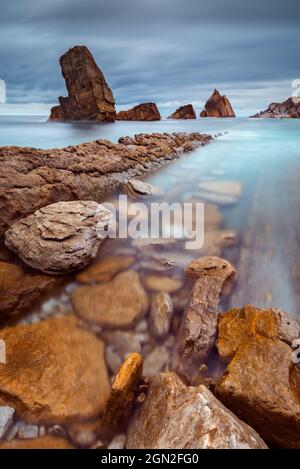 SPANIEN, KANTABRIEN, LIENCROS. BLICK VON UNTEN AUF DEN STRAND VON ARNIA MIT SEINEN GESCHNITTENEN FELSEN Stockfoto