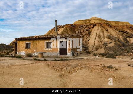 SPANIEN, SPANISCHES BASKENLAND. NAVARRA, WÜSTE DES BARDENAS, SCHAFSTALL IN TON NEBEN EINEM HÜGEL Stockfoto