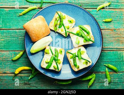 Gemüsebruschetta mit Brokkoli, grünen Erbsen und Spargelbohnen.Vegetarisches Essen Stockfoto