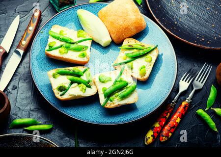 Gemüsebruschetta mit Kohl, grünen Erbsen und Spargelbohnen Stockfoto