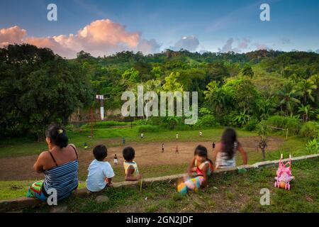 Frauen und Kinder von Embera aus indien schauen sich ein Fußballspiel im Dorf La Bonga neben Rio Pequeni, Republik Panama, Mittelamerika an. Stockfoto