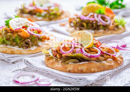 Griechisches Gyros-Fleisch mit Pita-Fladenbrot, Gemüse und Zwiebeln und Tzatziki-Dip auf weißem Hintergrund Stockfoto