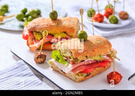 Hausgemachtes Ciabatta-Sandwich mit Guacamole, Prosciutto, Salat und Tomaten Stockfoto
