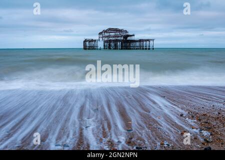 Die Wellen, die an den Ruinen des Brighton West Pier im Osten von Sussex im Südosten von England zurückweichen, haben bessere Tage gesehen Stockfoto