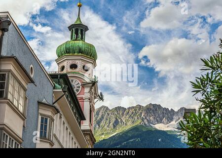 Uhr und Aussichtsturm aus dem 15. Jahrhundert auf der Maria-Theresien-Straße, mit den österreichischen Alpen im Hintergrund. Innsbruck, Tirol, Österreich, Europa Stockfoto