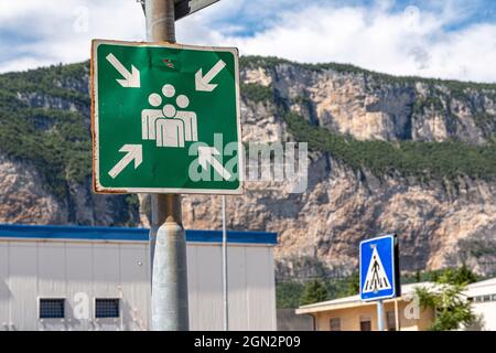 Wegweiser mit Symbolen, die eine Sammelstelle für Personen im Katastrophenfall anzeigen. Stockfoto