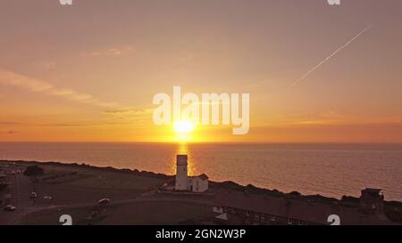 Hunstanton, Großbritannien. September 2021. Die Sonne erleuchtet das Meer in The Wash, kurz vor Sonnenuntergang und am 20. September 2021 hinter dem Old Hunstanton Leuchtturm in Hunstanton, Norfolk, Großbritannien, zu sehen.Quelle: Paul Marriott/Alamy Live News Stockfoto