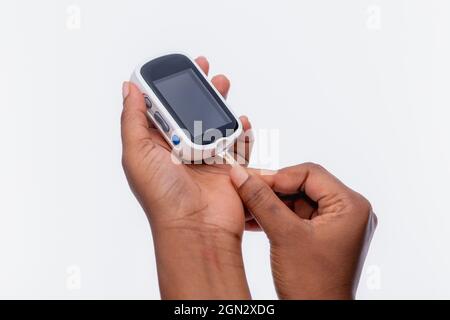 Nahaufnahme der Hände einer nicht erkennbaren Frau, die ein Glucometer hält Stockfoto