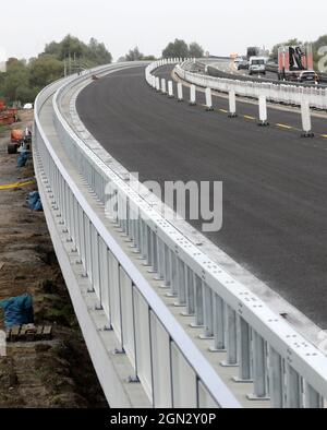 Tribsees, Deutschland. September 2021. Die Route westlich der neu gebauten Ostseestrada bei Tribsees (l) kurz vor der Verkehrsöffnung rollt rechts der Verkehr über die temporäre Brücke. Mit der Öffnung für den Verkehr ist nun die Hälfte der neu errichteten Strecke fertig, abgesehen von den verbleibenden Arbeiten an den Verkehrsleitseinrichtungen. Die A20 war im Herbst 2017 auf einem besonders sumpfigen Abschnitt in der Nähe von Tribsees abgeklungen und zusammengebrochen. Der komplette Neubau soll bis Ende 2023 fertiggestellt sein. Quelle: Bernd Wüstneck/dpa-Zentralbild/dpa/Alamy Live News Stockfoto