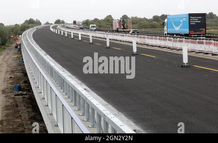 Tribsees, Deutschland. September 2021. Die Route westlich der neu gebauten Ostseestrada bei Tribsees (l) kurz vor der Verkehrsöffnung rollt rechts der Verkehr über die temporäre Brücke. Mit der Öffnung für den Verkehr ist nun die Hälfte der neu errichteten Strecke fertig, abgesehen von den verbleibenden Arbeiten an den Verkehrsleitseinrichtungen. Die A20 war im Herbst 2017 auf einem besonders sumpfigen Abschnitt in der Nähe von Tribsees abgeklungen und zusammengebrochen. Der komplette Neubau soll bis Ende 2023 fertiggestellt sein. Quelle: Bernd Wüstneck/dpa-Zentralbild/dpa/Alamy Live News Stockfoto