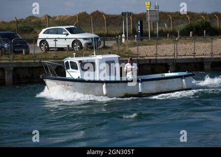 Ein kleines Fischerboot namens Sonny Jim, mit dem Fischer, der die Ausrüstung vorbereitet, um entlang des Flusses Arun in Littlehampton ins Meer zu fahren. Stockfoto