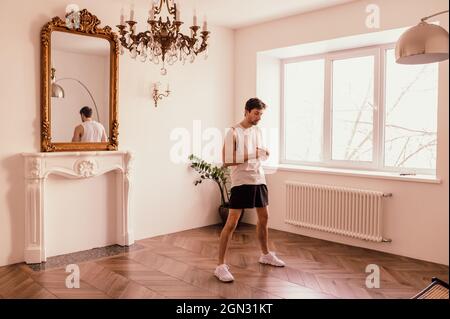 Der Mann, der sich selbst isoliert, geht zu Hause zum Sport. Stockfoto