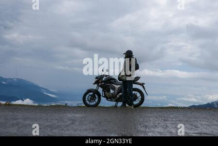 Bandipora, Jammu und Kaschmir, Indien. September 2021. Ein Biker steht am 21. September 2021 an einer abgelegenen Bergstraße hoch im Himalaya, die Srinagar mit Gilgit Baltistan im Distrikt Bandipora verbindet. Der Razdan-Pass ist der einzige Hochgebirgspass zwischen Srinagar und Gurez; er liegt auf einer Höhe von 11,672ft über dem Meeresspiegel. Die Straße über den Pass, genannt Bandipora-Gurez Autobahn, verbindet mehrere abgelegene Dörfer, einschließlich derjenigen in der Nähe der Loc mit Bandipora und Srinagar. Quelle: Adil Abbas/ZUMA Wire/Alamy Live News Stockfoto