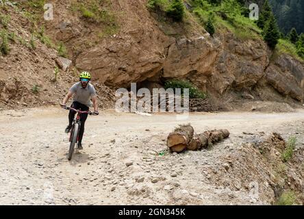 Bandipora, Jammu und Kaschmir, Indien. September 2021. Ein Mann fährt am 21. September 2021 auf einer abgelegenen Bergstraße hoch im Himalaya mit dem Fahrrad, die Srinagar mit Gilgit Baltistan im Distrikt Bandipora verbindet. Der Razdan-Pass ist der einzige Hochgebirgspass zwischen Srinagar und Gurez; er liegt auf einer Höhe von 11,672ft über dem Meeresspiegel. Die Straße über den Pass, genannt Bandipora-Gurez Autobahn, verbindet mehrere abgelegene Dörfer, einschließlich derjenigen in der Nähe der Loc mit Bandipora und Srinagar. Quelle: Adil Abbas/ZUMA Wire/Alamy Live News Stockfoto