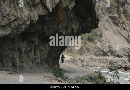 Bandipora, Jammu und Kaschmir, Indien. September 2021. Am 21. September 2021 fährt ein Mann mit dem Motorrad auf einer abgelegenen Bergstraße hoch im Himalaya, die Srinagar mit Gilgit Baltistan im Distrikt Bandipora verbindet. Der Razdan-Pass ist der einzige Hochgebirgspass zwischen Srinagar und Gurez; er liegt auf einer Höhe von 11,672ft über dem Meeresspiegel. Die Straße über den Pass, genannt Bandipora-Gurez Autobahn, verbindet mehrere abgelegene Dörfer, einschließlich derjenigen in der Nähe der Loc mit Bandipora und Srinagar. Quelle: Adil Abbas/ZUMA Wire/Alamy Live News Stockfoto