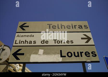 LISSABON, PORTUGAL - 13. Jul 2021: Eine Aufnahme eines Straßenschildes zu verschiedenen Zielen von Lissabon vor blauem Himmel Stockfoto