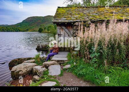 Ein altes, verderbtes Moos bedecktes Bootshaus am Grasmere See in der Nähe von Ambleside in den Seen. Stockfoto