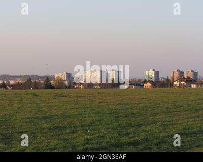 Grasfeld und Wohnblöcke in der europäischen Stadt Bielsko-Biala im schlesischen Bezirk in Polen, klarer blauer Himmel in 2020 warmen sonnigen Frühlingstag am April. Stockfoto