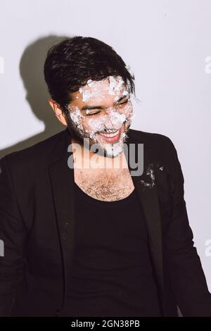 Junge Frau mit langen welligen blonden Haaren in lässig warm Outfit sitzend wegschauen während ruhen Stockfoto