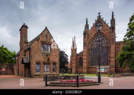 Kathedrale von Carlisle (die Kathedrale der Heiligen und ungeteilten Dreifaltigkeit) mit Cathedral Lodge Antiques auf der linken Seite. Cumbria, England, Großbritannien Stockfoto