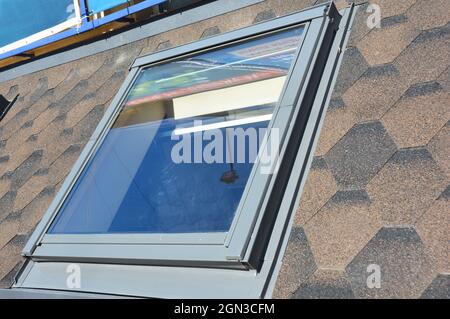 KIEW, UKRAINE - 27. Dezember 2018: Nahaufnahme der Dachfenster-Reparatur mit Abdichtungsbahn auf Asphaltschindeldach. Dachkonstruktion Stockfoto