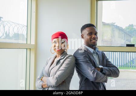 Frau und Mann stehen in Business-Outfits Seite an Seite. Stockfoto