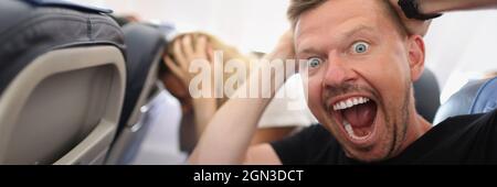 Mann, der im Flugzeug fliegt und vor Angst schreit Stockfoto
