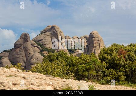 Abgerundete erodierte Berge der Sierra de Montserrat mit blauem Himmel und dünnen Wolken Katalonien Spanien Stockfoto