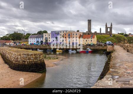 Eingang zum malerischen Hafen von St Andrews an der Ostküste von Fife, Schottland, mit dem hohen St. Rules Tower im Hintergrund. Stockfoto