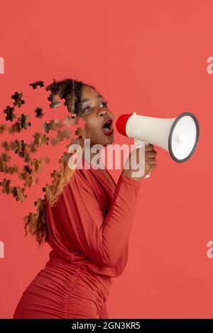 Kreative Collage einer jungen afrikanerin, die im Megaphon spricht. Weiblicher Kopf bestehen aus Puzzleteilen Stockfoto