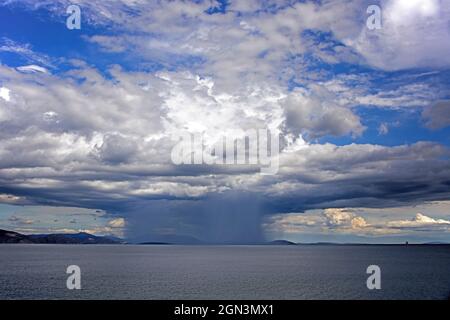 Gewitter auf einem Teil des Landes und des Meeres unter den schweren Cumulomnibus-Wolken Stockfoto