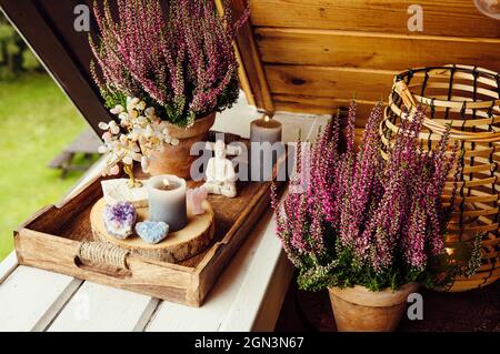 Spirituelles Home Balkon Dekor mit rosa Heidekraut Blumen, Kerzenlicht Flamme, Kristall Geoden, Kristall Draht Baum und kleine Buddha-Figur. Niedlicher Herbst sp Stockfoto