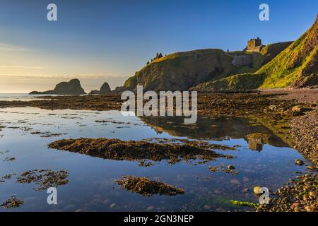 Dunnottar Castle badete in der Morgensonne, aufgenommen von Castle Haven in der Nähe von Stonehaven in Aberdeenshire. Stockfoto