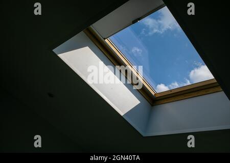 Dachboden. Blick aus dem Fenster. Blick auf den Himmel vom Fenster aus. Oberlicht. Licht im Haus Stockfoto