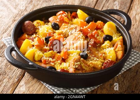Galinha ein portugiesisches traditionelles Hühnergericht aus Macau, das in der Pfanne auf dem Tisch aus nächster Nähe serviert wird. Horizontal Stockfoto