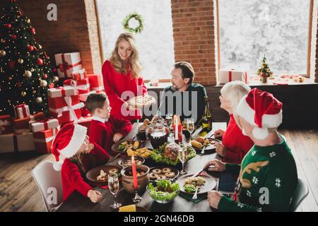 Portrait von attraktiven fröhlichen Familie verbringen Eve Noel Tag essen köstliche Gerichte zu Hause Loft Haus drinnen Stockfoto