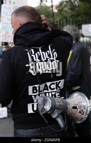 London, Großbritannien. September 2021. Während des Anti-Impfungs- und Anti-Blockdown-Protests wird ein Protestler mit einem Kapuzenpullover mit den Worten Rebel Squad und einem Megaphon gesehen.Anti-Impfungs- und Anti-Blockdown-Demonstranten demonstrieren vor der Downing Street, während der Premierminister Boris Johnson eine Umbildung seines Kabinetts durchführt. (Foto von Jason Brown/SOPA Images/Sipa USA) Quelle: SIPA USA/Alamy Live News Stockfoto