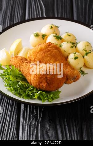 Wiener Backhendl Wiener gebratenes Huhn zubereitet und gewürzte Portionen Huhn, die paniert und knusprig frittiert mit Zitrone und Kartoffel serviert werden Stockfoto