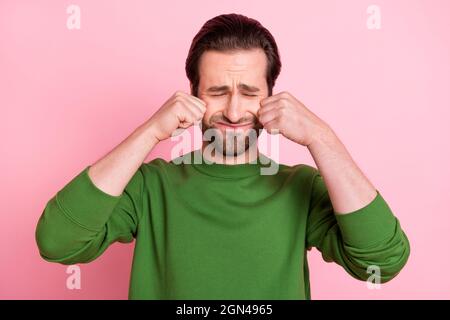 Foto von unzufrieden launisch Person geschlossenen Augen Arme wischen Tränen tragen Pullover auf rosa Hintergrund isoliert Stockfoto