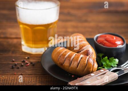 Würstchen und Bier auf Holztisch. Oktoberfest, Grillbar-Menü-Konzept Stockfoto